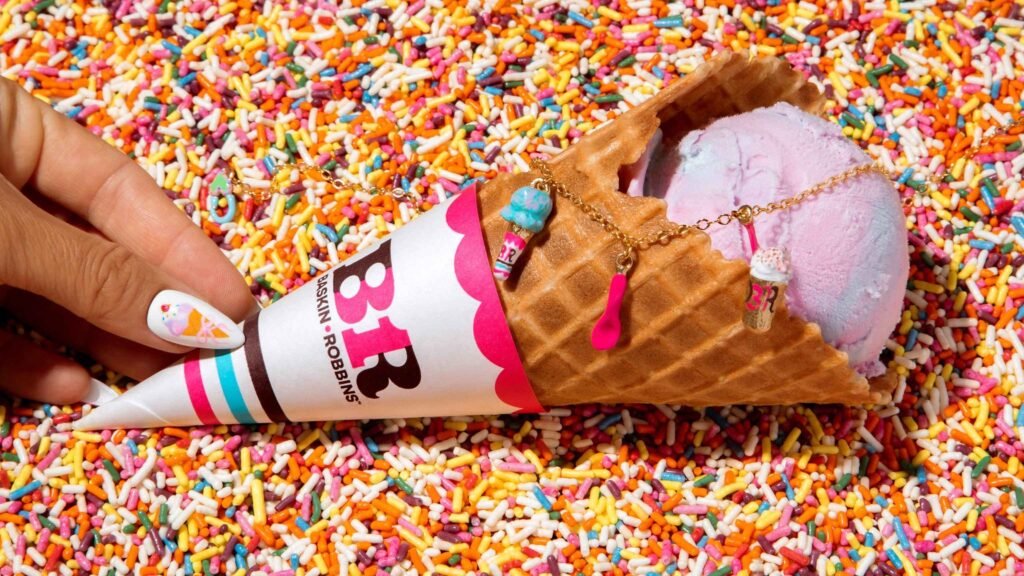 A display of multicolored Baskin-Robbins ice cream scoops in a waffle cone and cup.