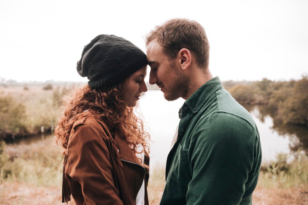 Couple holding hands, smiling, and leaning against each other, side by side