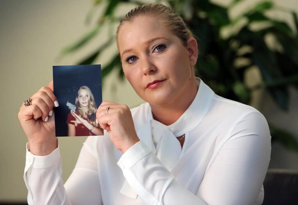 Virginia Giuffre holding a photo of herself as a teenager during an interview.